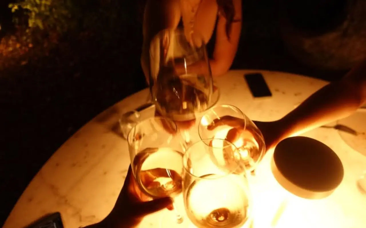 A candlelit dinner table among guests