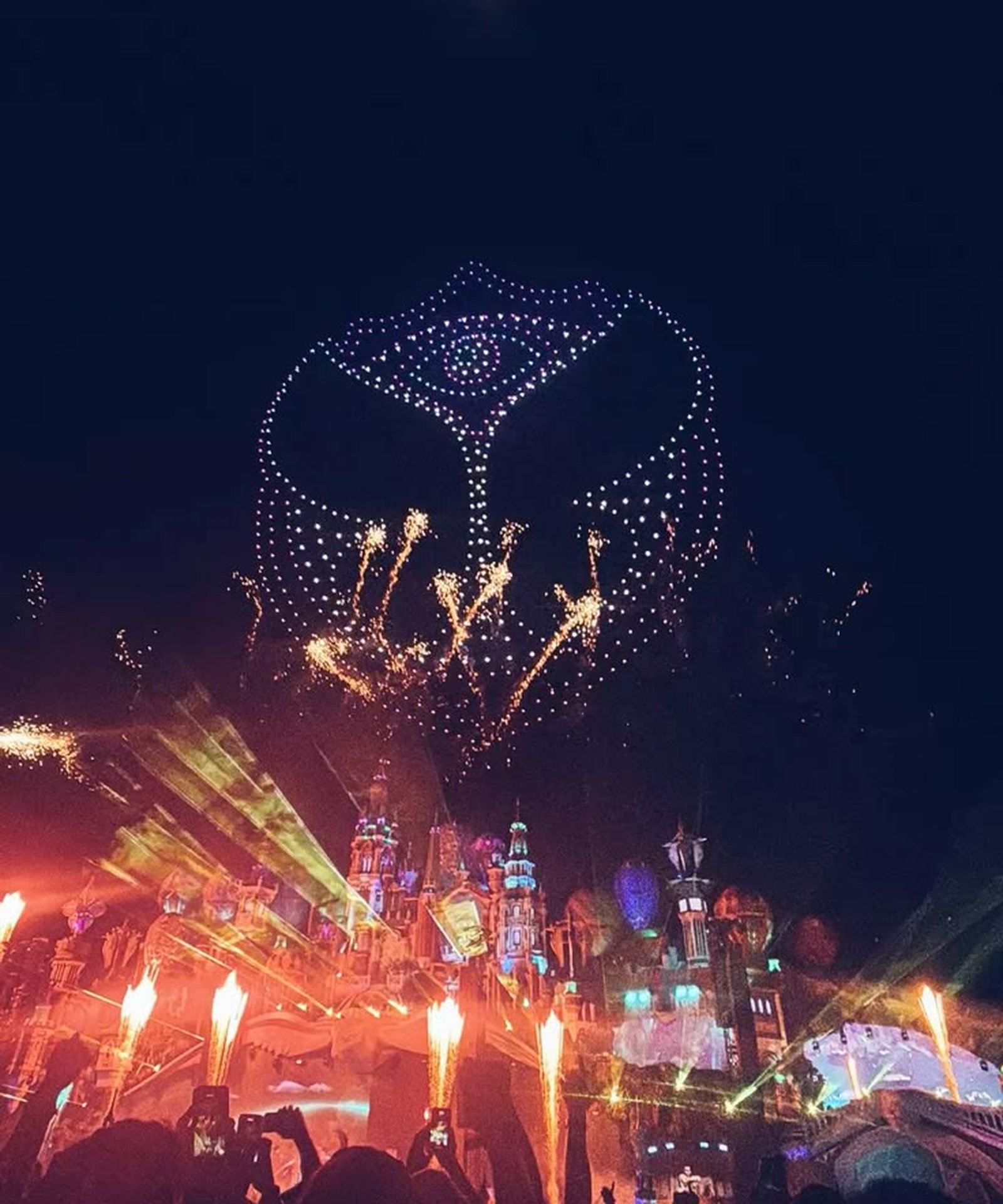 The Tomorrowland mainstage at night, drones over the crowd